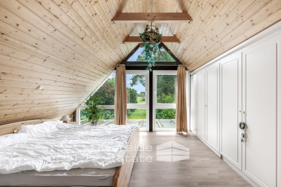 Elternschlafzimmer mit praktischen Einbauschränken und Ausblick in den Garten